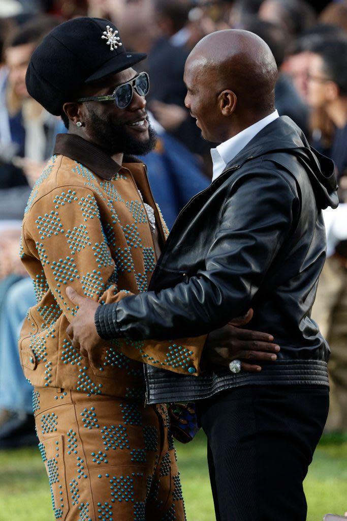 Former Ivorian football player Didier Drogba (R) embraces Nigerian singer Burna Boy (L) during the Louis Vuitton Spring/Summer 2025 menswear ready to wear presentation as part of Paris Fashion Week in Paris on 18 June.