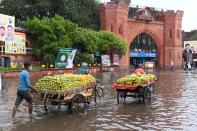 Street vendors make their way along a water-logged street following heavy rains in Amritsar on July 19, 2020. (Photo by NARINDER NANU / AFP) (Photo by NARINDER NANU/AFP via Getty Images)