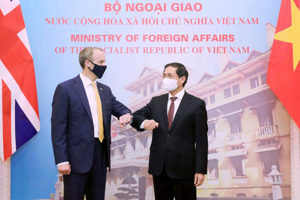Britain's Foreign Secretary Dominic Raab, left, and Vietnamese Foreign Minister Bui Thanh Son greet with an elbow bump in Hanoi, Vietnam, Tuesday, Jun. 22, 2021. The Britain's top diplomat is on a three-nation visit in Southeast Asia to promote closer ties and trade with the region following the U.K.'s exit from the European Union. (Bui Lam Khanh/VNA via AP)