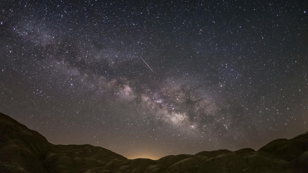  a meteor streaks through a clear night sky 