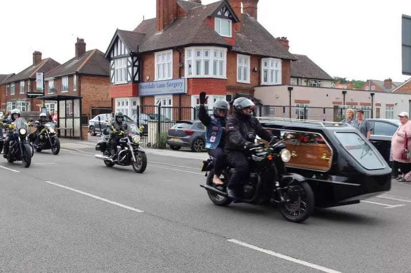 Bev on the back of the bike which had Kevin's coffin attached