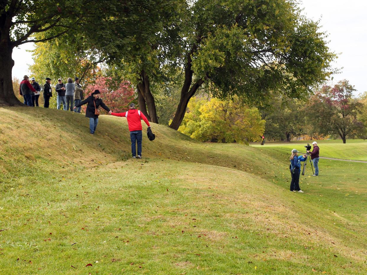 Don and Karen Hostler, of Westerville, help each other off of Observatory Mound at Octagon Earthworks after a tour Oct. 15. The Ohio History Connection held events at the Great Circle and Octagon Earthworks to celebrate their designation as UNESCO World Heritage Sites.