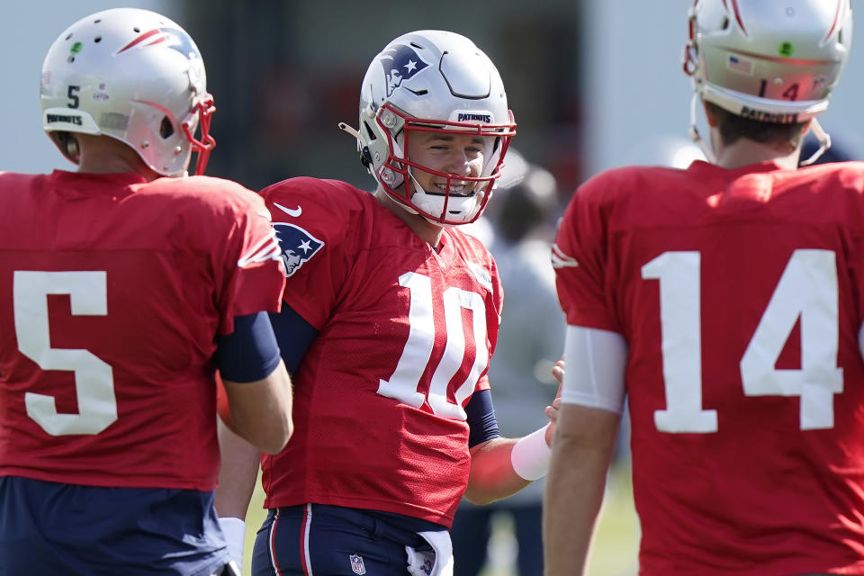 New England Patriots quarterback Mac Jones (10) speaks with quarterbacks Brian Hoyer (5) and Garrett Gilbert (14) during an NFL football practice, Wednesday, Oct. 20, 2021, in Foxborough, Mass. (AP Photo/Steven Senne)