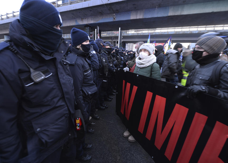 People face police, during a protest on International Women's Day, in Warsaw, Poland, Monday March 8, 2021. Women’s rights activists in Poland marked International Women’s Day on Monday caught between reasons to celebrate and a heavy sense that they are facing a long battle ahead. This year’s Women’s Day, which is being marked with protests, comes after a near total ban on abortion took effect in January in the historically Roman Catholic country, a step that had long been been sought by the conservative ruling party, Law and Justice. (AP Photo/Czarek Sokolowski)