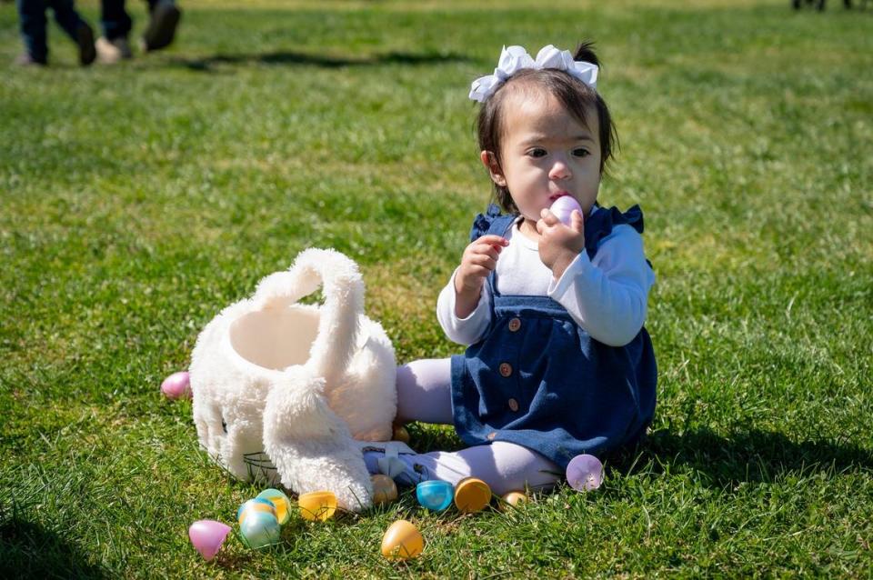 Valeria Gil, 1, taste tests her plastic egg after the Haggin Oaks Easter Egg Hunt on Sunday, April 9, 2023, in Sacramento.