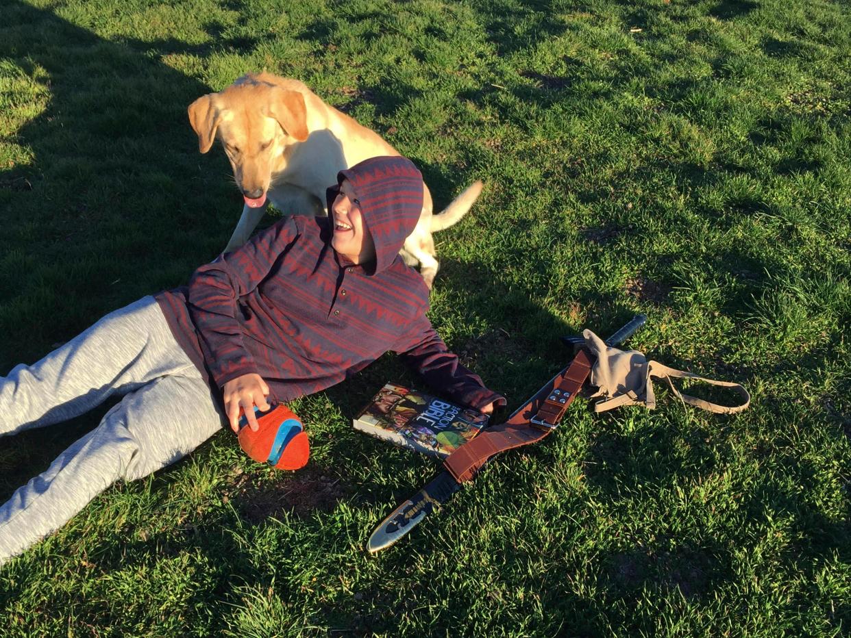 This 2016 image provided by Mark Mansfield shows his son Canyon Mansfield and dog Kasey playing in the grass in Pocatello, Idaho. The boy was seriously injured in 2017 and his dog was killed when a cyanide device that is used to kill coyotes and other predators emitted a cloud of poison while they were hiking near their home. The Bureau of Land Management made public its decision to end the use of the devices on public lands on Nov. 22.