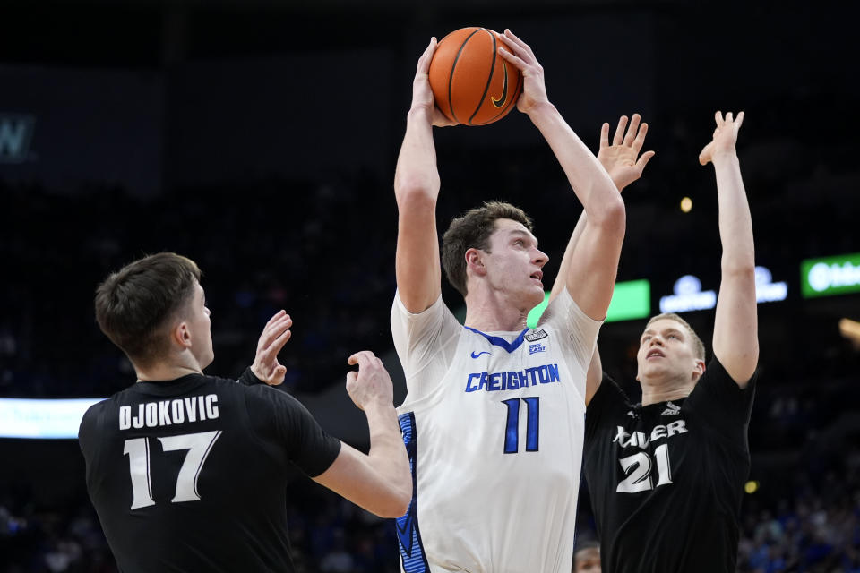 Creighton center Ryan Kalkbrenner (11) drives to the basket between Xavier forward Lazar Djokovic (17) and forward Sasa Ciani (21) during the first half of an NCAA college basketball game, Tuesday, Jan. 23, 2024, in Omaha, Neb. (AP Photo/Charlie Neibergall)