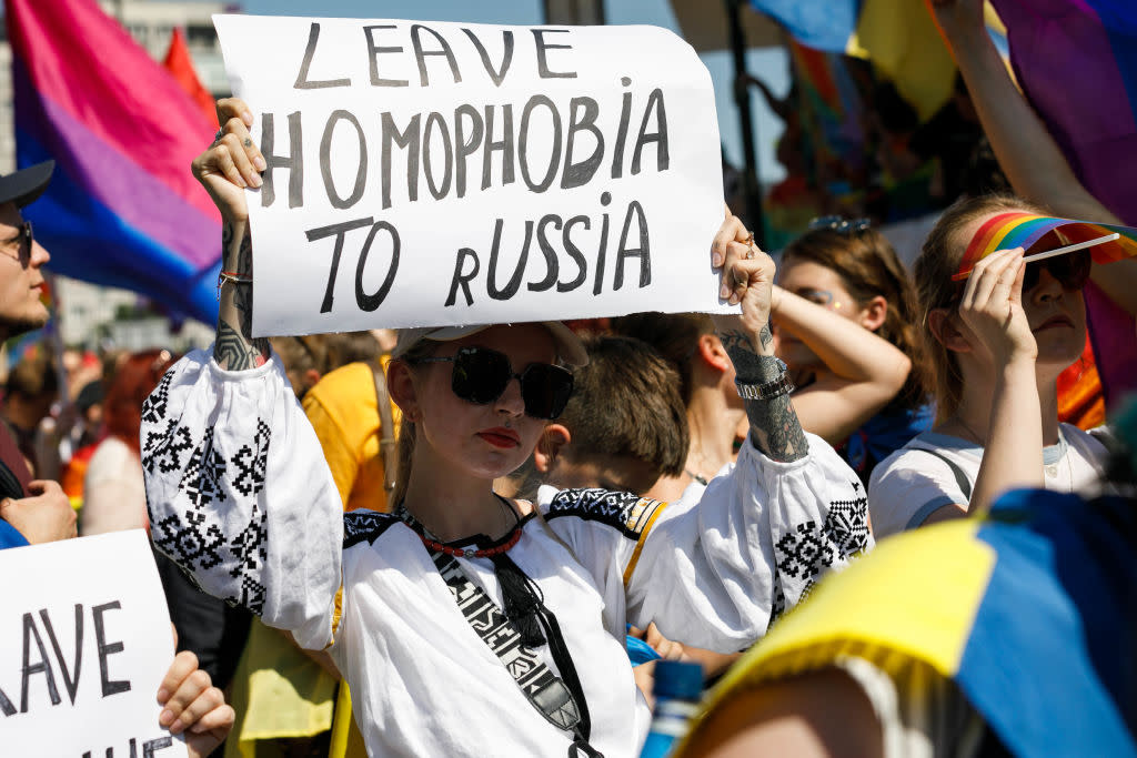 A woman holds a placard saying "Leave homophobia to Russia