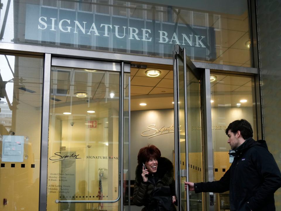 A woman leaves a branch of Signature Bank in New York, Monday, March 13, 2023.