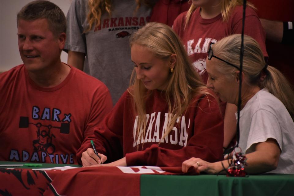 Rock Bridge volleyball star Lily Dudley ceremoniously signs with Arkansas during a National Signing Day celebration at Rock Bridge High School on Nov. 10, 2022.