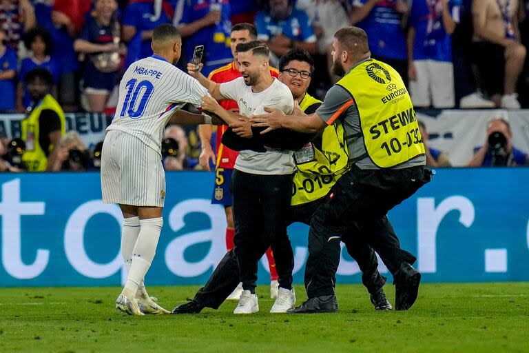 El intruso que quiso fotografiarse con él fue atrapado en seguida, como Mbappé por los defensores españoles en la primera semifinal de Alemania 2024.