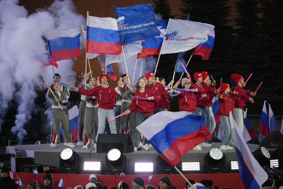 Young people participate in a concert marking the 10-year anniversary of Crimea's annexation by Russia on Red Square in Moscow, Russia, Monday, March 18, 2024. President Vladimir Putin seized Crimea from Ukraine a decade ago, a move that sent his popularity soaring but was widely denounced as illegal. (AP Photo/Alexander Zemlianichenko)