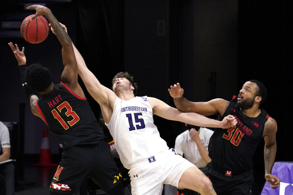 Northwestern center Ryan Young, center, battles for a rebound against Maryland guard Hakim Hart, left, and forward Galin Smith during the first half of an NCAA college basketball game in Evanston, Ill., Wednesday, March 3, 2021. (AP Photo/Nam Y. Huh)