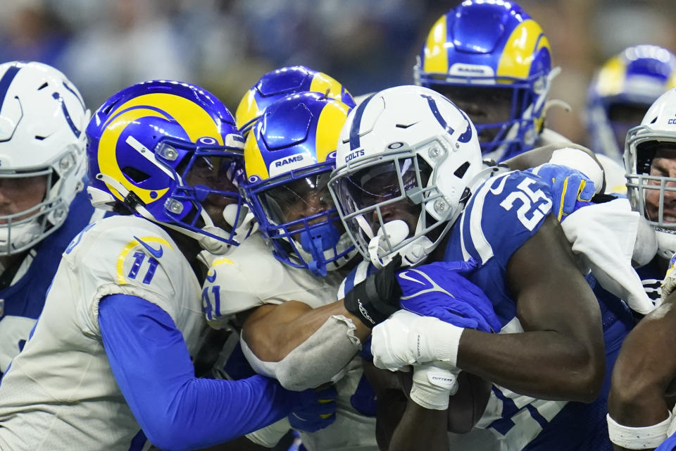 Indianapolis Colts' Marlon Mack (25) is tackled by Los Angeles Rams' Darious Williams (11) and Kenny Young (41) during the second half of an NFL football game, Sunday, Sept. 19, 2021, in Indianapolis. (AP Photo/Michael Conroy)