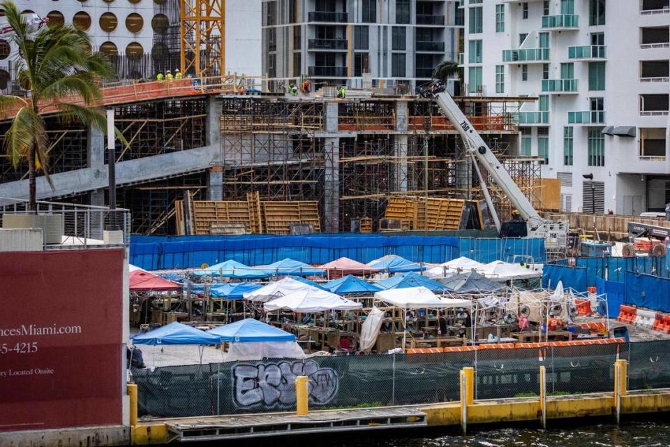 Arqueólogos trabajan bajo lonas en la excavación de un extenso sitio indígena prehistórico en el río Miami, en Brickell, donde el urbanizador Related Group está construyendo dos nuevas torres. En el extremo izquierdo, una esquina de 444 Brickell Avenue, que Related planea demoler para construir una tercera torre. La junta de conservación histórica de Miami declaró al terreno monumento arqueológico, pero eso no impedirá que Related construya en él.