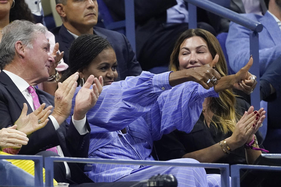 Michelle Obama (centro) saluda a Frances Tiafoe durante la semifinal entre Tiafoe y Carlos Alcaraz en el US Open, el viernes 9 de septiembre de 2022, en Nueva York. (AP Foto/John Minchillo)
