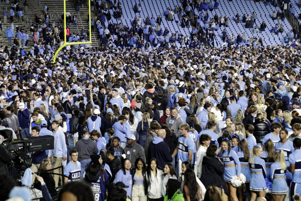 North Carolina fans take the field after North Carolina defeated rival Duke in two overtimes in an NCAA college football game Saturday, Nov. 11, 2023, in Chapel Hill, N.C. (AP Photo/Chris Seward)