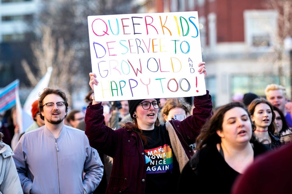 A person carries a sign reading "Queer kids deserve to grow old and happy too!" during a Trans Day of Visibility event, Saturday, April 1, 2023, in Iowa City, Iowa.