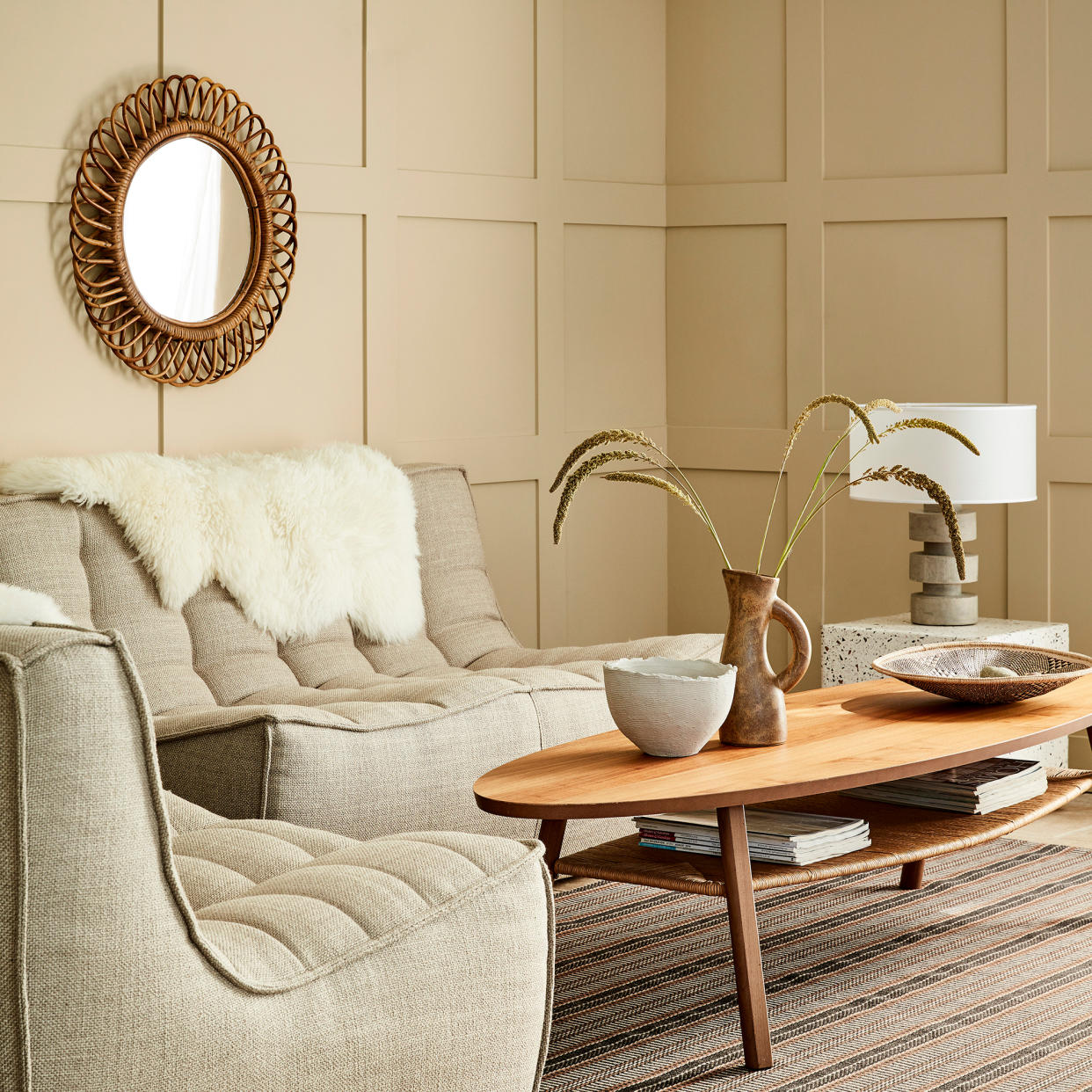  Grey living room with sofa, coffee table, fireplace and bookshelves. 