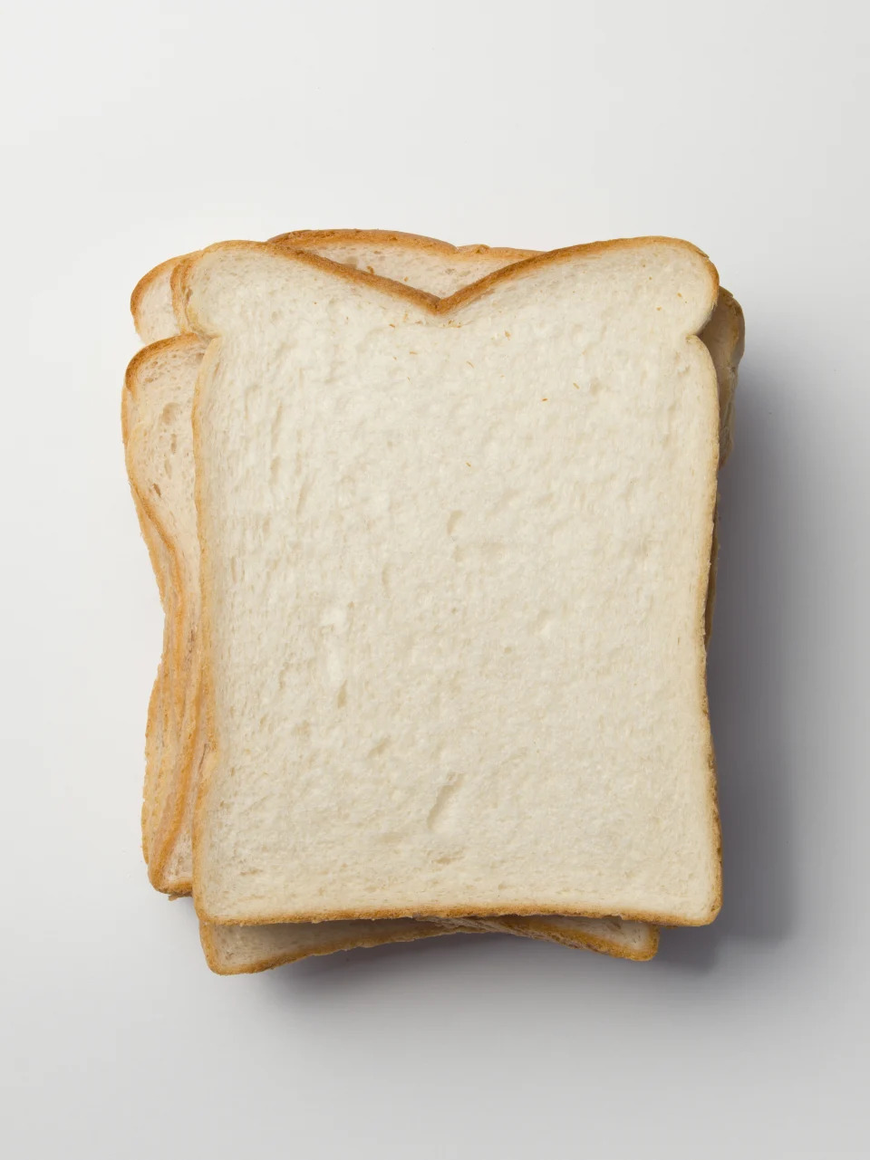 A stack of plain white bread slices is shown, possibly related to an article categorized under Work & Money