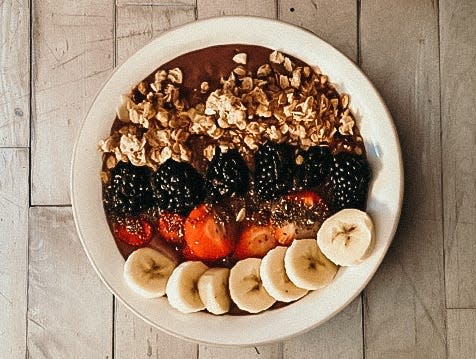 smoothie bowl with granola, blackberries, strawberries, chia seeds, and banana