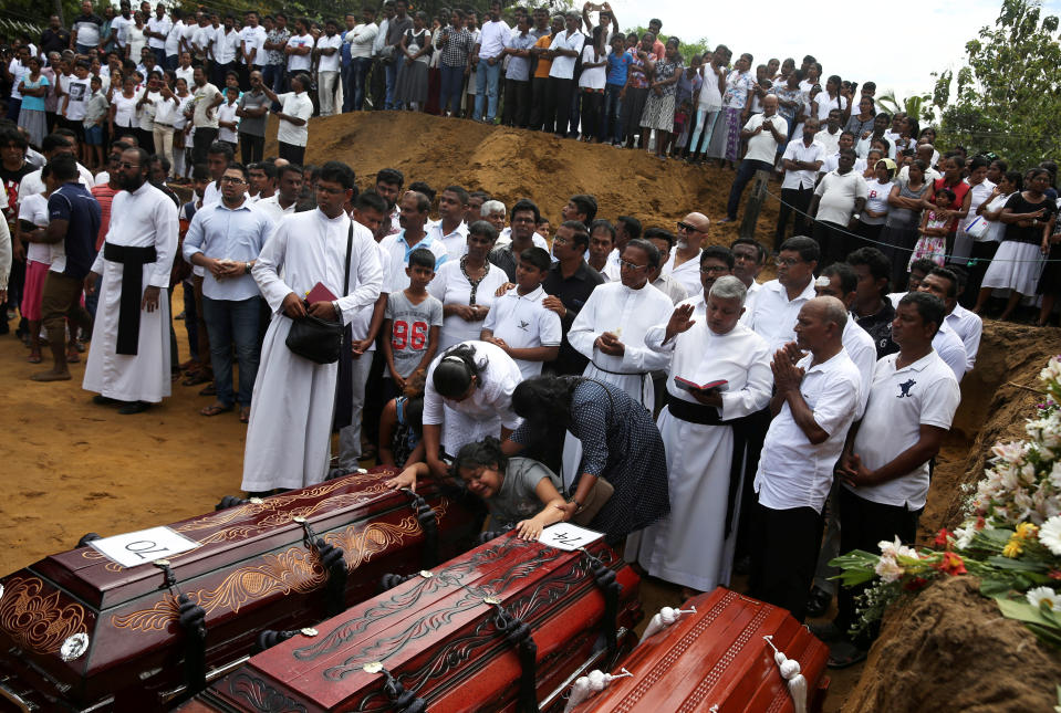 A woman reacts next to two coffins during a mass burial of victims, two days after a string of suicide bomb attacks on churches and luxury hotels across the island on Easter Sunday, at a cemetery near St. Sebastian Church in Negombo, Sri Lanka, April 23, 2019.  (Photo: Athit Perawongmetha/Reuters)