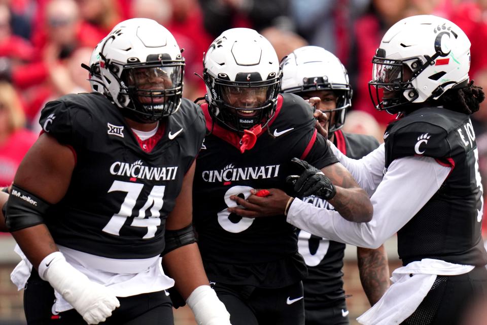 Cincinnati Bearcats wide receiver Xzavier Henderson (8) is congratulated by Cincinnati Bearcats quarterback Emory Jones (5), right, after catching a touchdown pass in the second quarter during a college football game between the Baylor Bears and the Cincinnati Bearcats, Saturday, Oct. 21, 2023, at Nippert Stadium in Cincinnati.