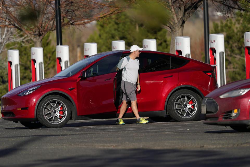 A motorist charges a 2020 Model Y at a Tesla supercharging station located in the parking lot of Colorado Mills outlet mall Wednesday, Nov. 17, 2020, in Golden, Colo. (AP Photo/David Zalubowski)