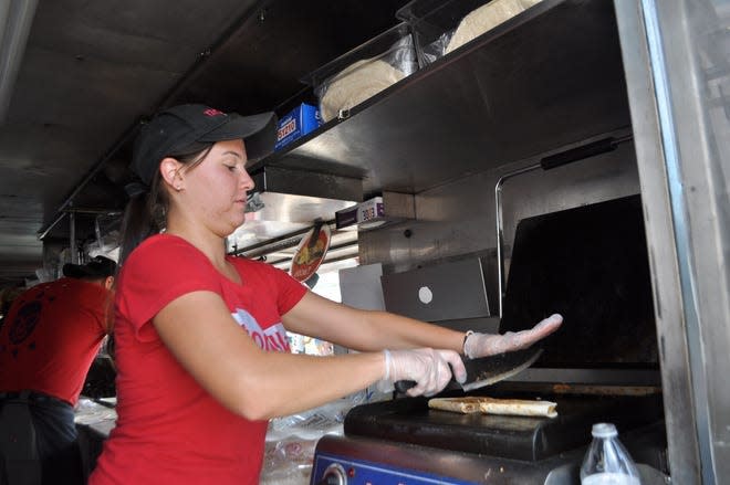 Alissa Wulf, a manager at Tortilla Street Food, prepares a quesadilla at the 2021 Columbus Food Truck Festival last August at the Franklin County Fairgrounds in Hilliard. The festival is to return to the fairgrounds Aug. 19-21.