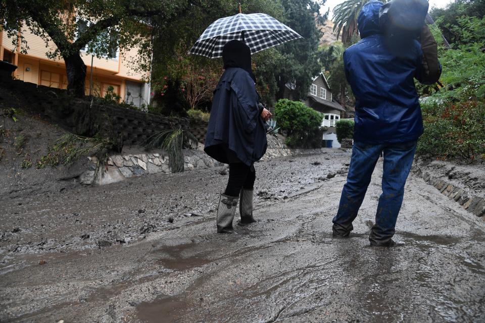 Journalists stand in ankle-deep mud in Burbank.