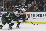 Arizona Coyotes defenseman Shayne Gostisbehere (14) handles the puck against Minnesota Wild center Mason Shaw (15) during the first period of an NHL hockey game Sunday, Nov. 27, 2022, in St. Paul, Minn. (AP Photo/Stacy Bengs)