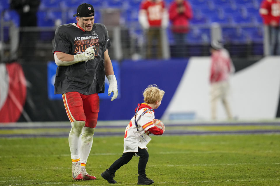 Kansas City Chiefs linebacker Drue Tranquill walks with is son Eli, 4, on the field after an AFC Championship NFL football game against the Baltimore Ravens, Sunday, Jan. 28, 2024, in Baltimore. The Kansas City Chiefs won 17-10. (AP Photo/Julio Cortez)