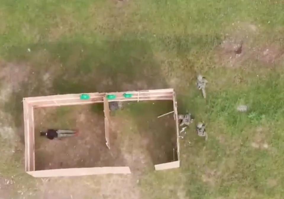 Chinese soldiers demonstrated how to break through a plywood wall during an outdoor combat exercise.