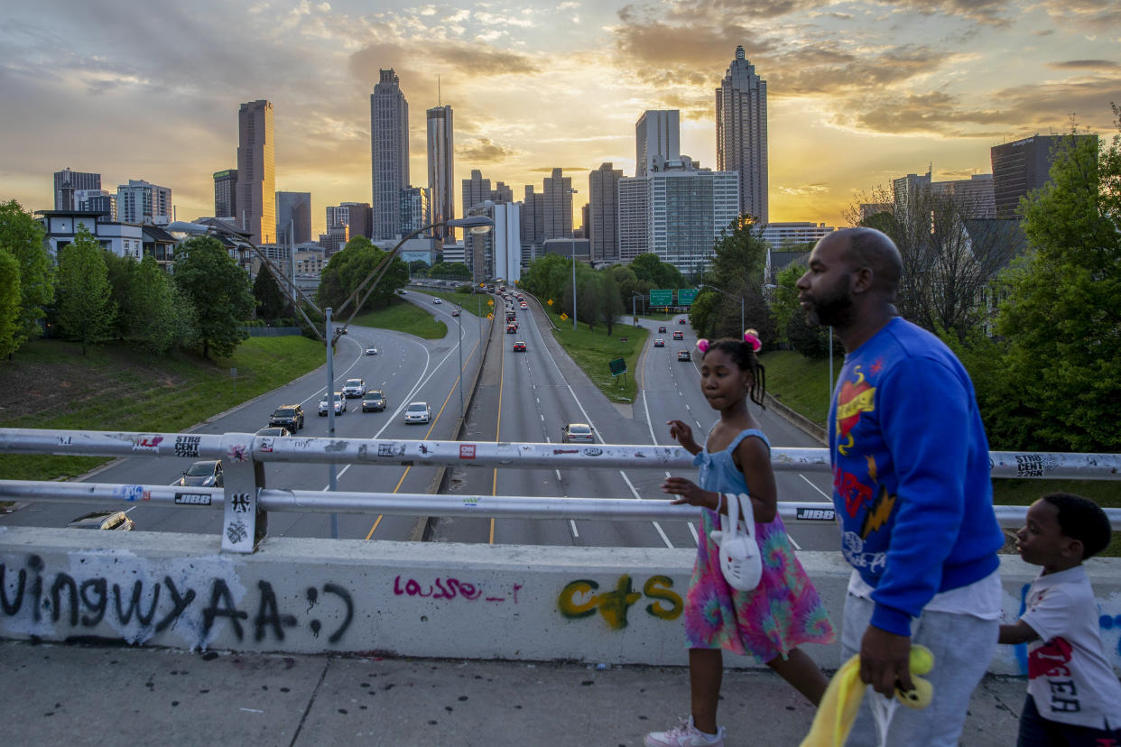 People walk along the Jackson Street Bridge in Atlanta, April 14, 2024. (Alyssa Pointer/The New York Times)