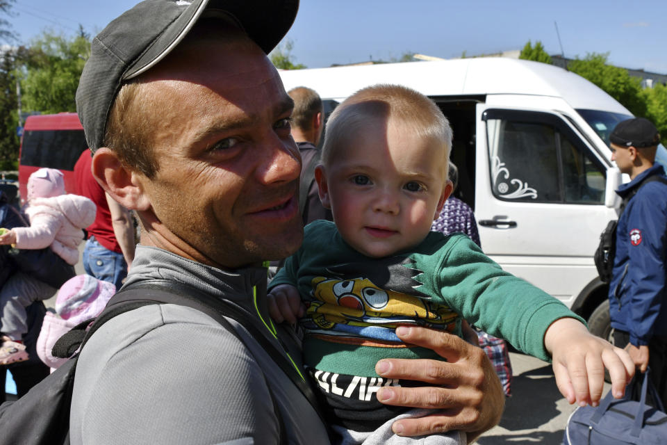 Leonid, 30, holds his son Sergei, 1, as they wait for boarding during an evacuation of civilians in Kramatorsk, Ukraine, Tuesday, May 3, 2022. (AP Photo/Andriy Andriyenko)