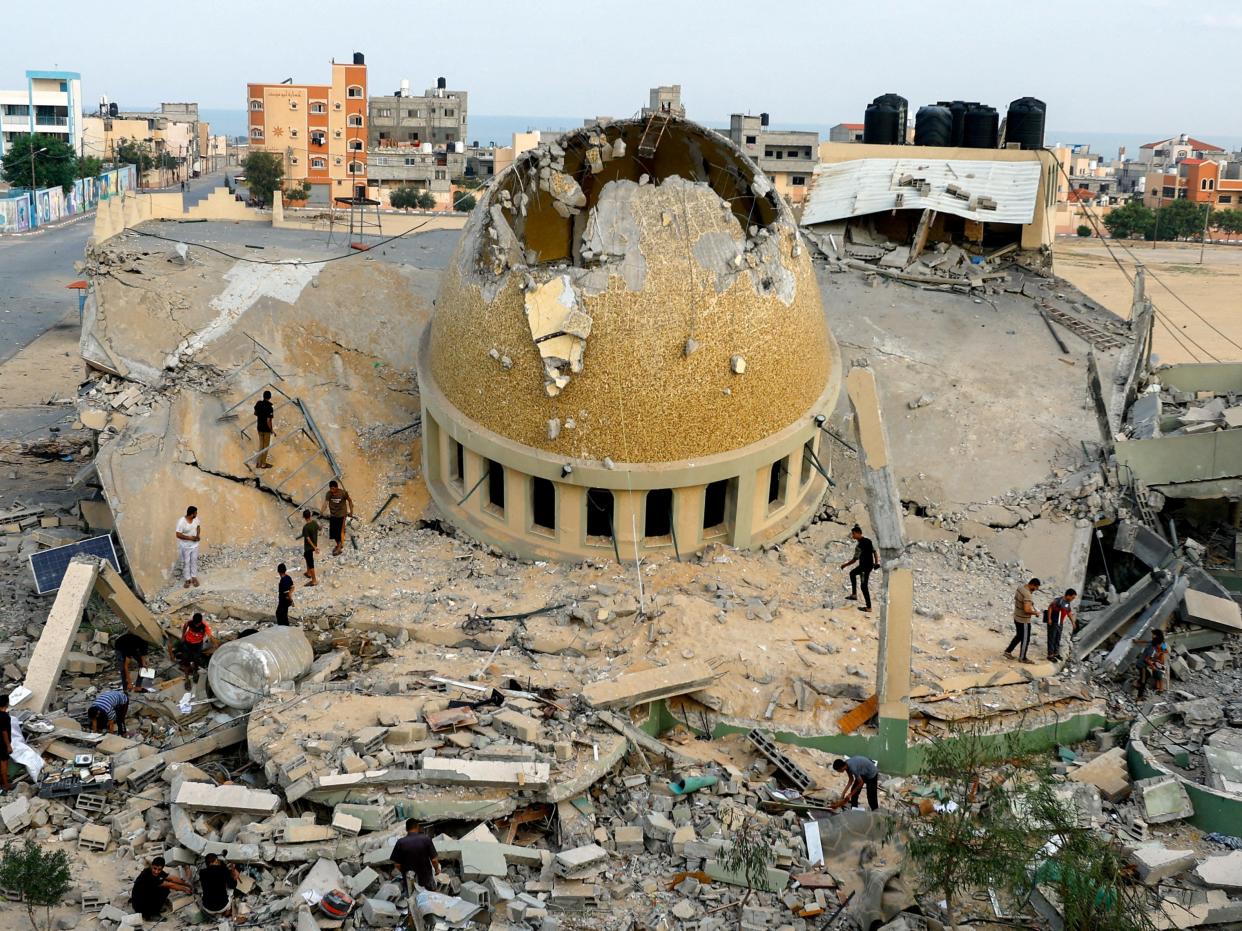 Palestinians inspect a mosque destroyed in Israeli strikes in Khan Younis, in the southern Gaza Strip (REUTERS)