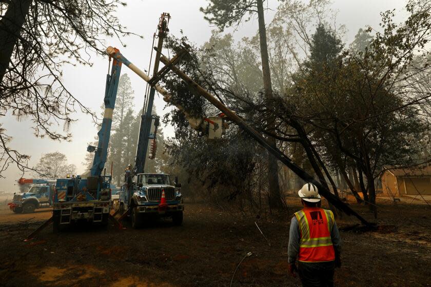 Carolyn Cole  Los Angeles Times PG&E CREWS clear a damaged power pole after the wildfire, which state investigators blamed on the utility's equipment.