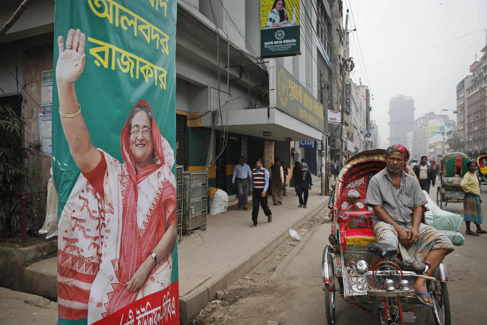 A cycle rickshaw driver waits for customers near a poster of Bangladeshi Prime Minister Sheikh Hasina during a 48-hour general strike called by the opposition to protest Sunday's election, in Dhaka, Bangladesh, Monday, Jan. 6, 2014. Bangladesh's ruling Awami League won one of the most violent elections in the country's history, marred by street fighting, low turnout and a boycott by the opposition that made the results a foregone conclusion. (AP Photo/Rajesh Kumar Singh)