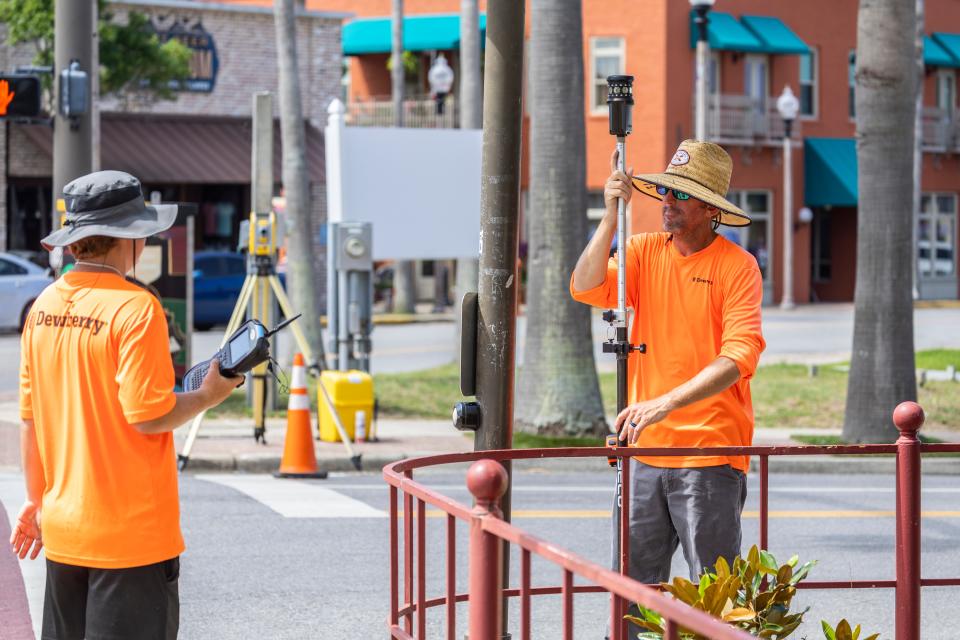 Dewberry employees Brady Gainous, left, and Keith Sawyer conduct a field survey in downtown Panama City on June 17.