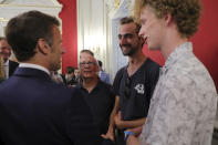 French President Emmanuel Macron meets Henri, second right, the 24-year-old 'backpack hero', his friend Lilian and Youssouf, who suffered minor stab wounds as he tried to intercept the suspect as he fled, in Annecy, French Alps, Friday, June 9, 2023. A man with a knife stabbed four young children at a lakeside park in the French Alps on Thursday June 8, 2023, assaulting at least one in a stroller repeatedly. Authorities said the children, between 22 months and 3 years old, suffered life-threatening injuries, and two adults were also wounded. (Denis Balibouse/Pool via AP)