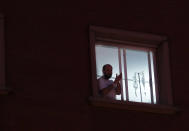 Un paciente del Hospital Virgen del Rocío de Sevilla participa en el aplauso sanitario desde la ventana de su habitación. (Foto: Eduardo Briones / Europa Press / Getty Images).