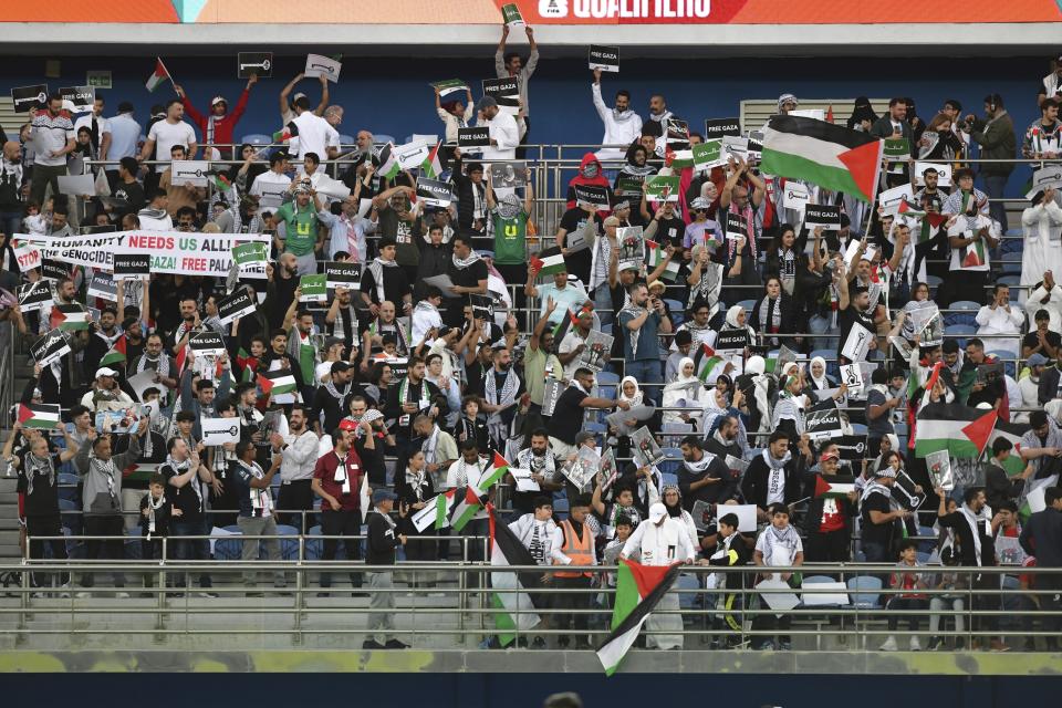 Palestinian fans wave Palestine national flags and hold pro Palestinian banners during a qualifying soccer match against Australia of the FIFA World Cup 2026 at Jaber Al -Ahmad stadium in Kuwait, Tuesday, Nov. 21, 2023. (AP Photo/Jaber Abdulkhaleg)