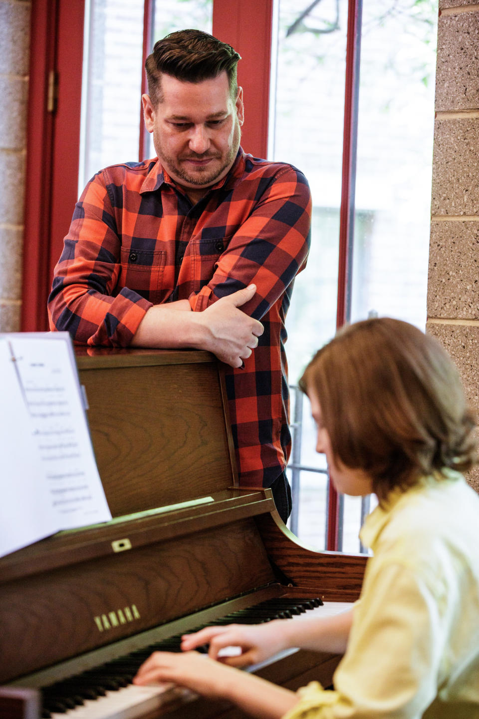 Steven Kroeze watches as Michael Coppola plays the piano during a vocal lesson at Trinity Lower East Side Lutheran Parish on May 28, 2022, in New York. (Julius Constantine Motal / NBC News)