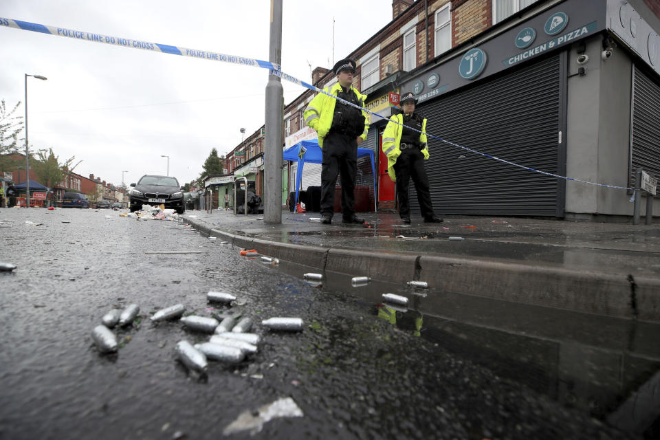 Police officers stand at the cordoned off area in Claremont Road in Manchester after a shooting Sunday, Aug. 12, 2018. Police in Manchester say some people have been hospitalized as the result of a shooting after a Caribbean carnival in the city. (Peter Byrne/PA via AP)