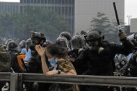 In this photo taken on Wednesday, June 12, 2019,a protester reacts as she is tackled by a riot police officer near the Legislative Council in Hong Kong. Young Hong Kong residents protesting a proposed extradition law that would allow suspects to be sent to China for trial are seeking to safeguard their identities from potential retaliation by authorities employing mass data collection and sophisticated facial recognition technology. (AP Photo/Kin Cheung)