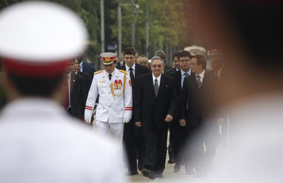 Cuban President Raul Castro, center, arrives at the mausoleum of former Communist leader Ho Chi Minh for a wreath-laying ceremony in Hanoi, Vietnam, Monday, July 9, 2012. (AP Photo/Na Son Nguyen).