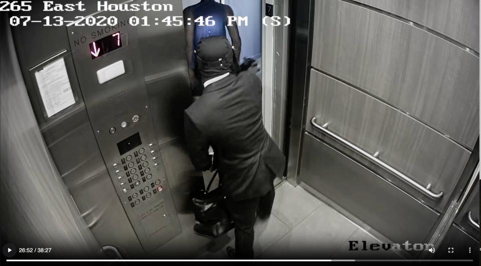 Tyrese Haspil shocks Fahim Saleh in the back with a Taser as he exits the elevator. A small circle of light is seen on Haspil's back.