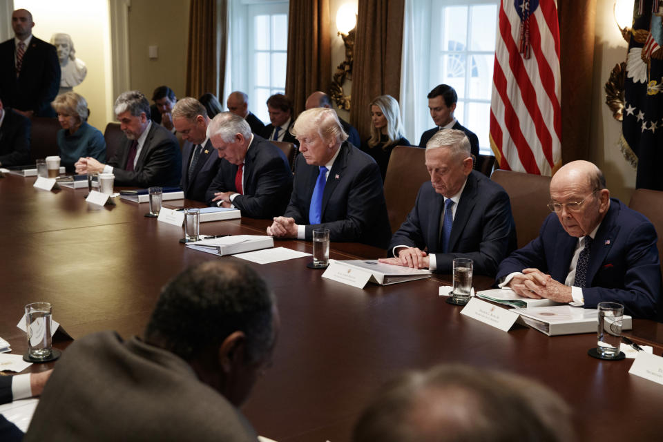 FILE - In this Wednesday, Dec. 20, 2017 file photo, President Donald Trump prays during a cabinet meeting at the White House in Washington. From left are Secretary of Education Betsy DeVos, acting Health and Human Services Secretary Eric Hargan, Secretary of Interior Ryan Zinke, Secretary of State Rex Tillerson, Trump, Secretary of Defense Jim Mattis, and Commerce Secretary Wilbur Ross. An opening prayer at a Monday, Oct. 21, 2019 Cabinet meeting by Housing and Urban Development Secretary Ben Carson, who asserted that the separation of church and state “doesn't mean that they cannot work together,” is raising new alarms among advocates for the non-religious _ adding to a growing list of Trump administration efforts to infuse religion into its rhetoric and policymaking. (AP Photo/Evan Vucci)