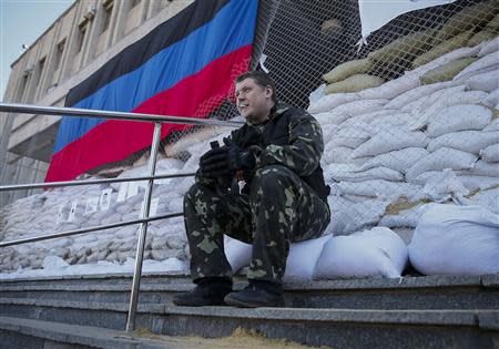 A pro-Russian armed man smokes as he guards near the mayor's office in Slaviansk April 25, 2014. REUTERS/Gleb Garanich