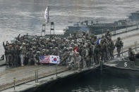 FILE - In this Dec. 10, 2015, file photo, U.S. and South Korean army soldiers pose on a floating bridge on the Hantan river after a river crossing operation, part of an annual joint military exercise between South Korea and the United States in Yeoncheon, South Korea. The South Korean and U.S. militaries have postponed on Thursday, Feb. 27, 2020, their annual joint drills out of concerns over a virus outbreak. (AP Photo/Ahn Young-joon, File)